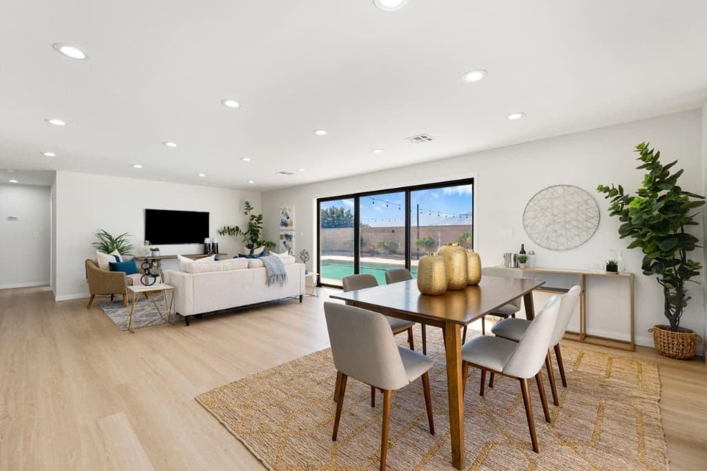 Open living and dining room looking out to a backyard pool — a home Value 4 Casa helps a family move forward